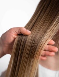 Person with smooth, shiny hair after keratin hair treatment