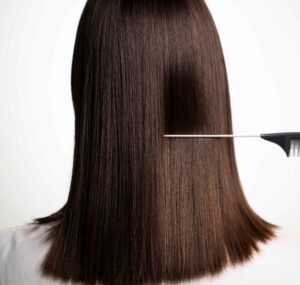 Person with smooth, shiny hair after keratin hair treatment